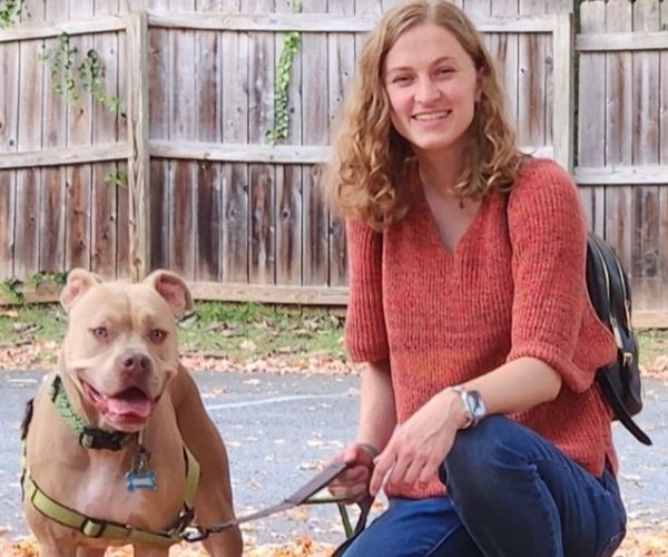 Dr. Amanda sitting on the floor with a dog