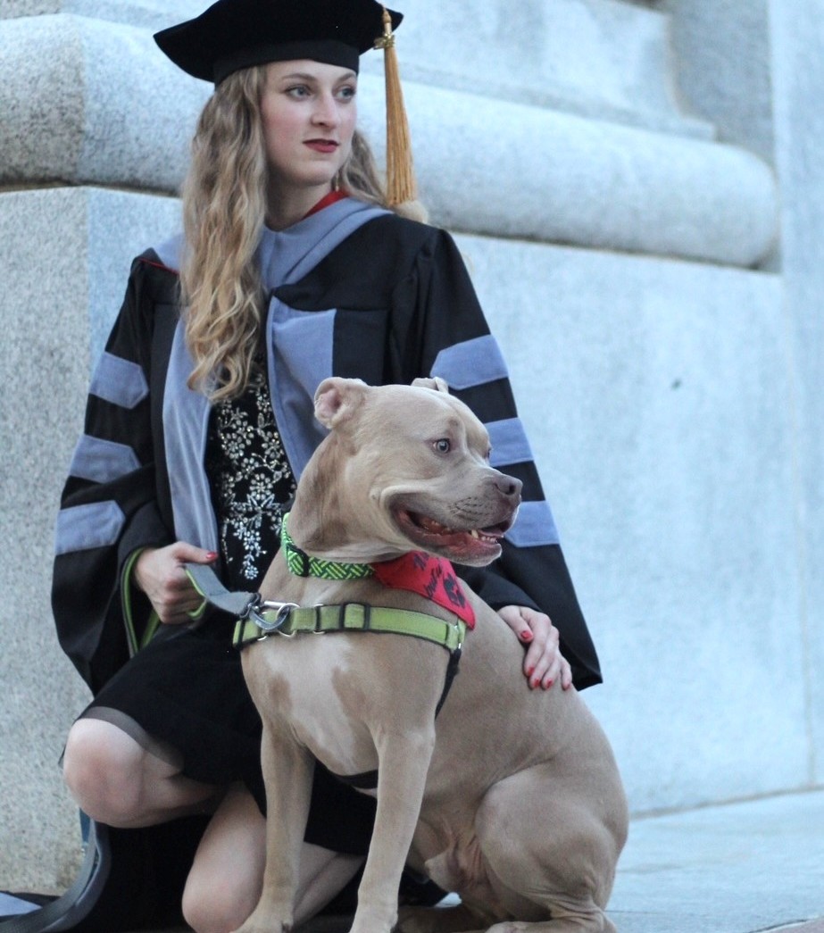 Dr. Amanda sitting on the floor with a dog